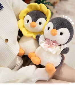 Close-up of soft plush penguin dolls with sunflower headpiece and pink satin bow detail