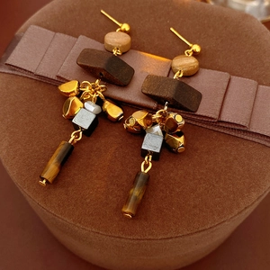 Detail of vintage geometric earrings with wood beads and tiger eye stone tassels