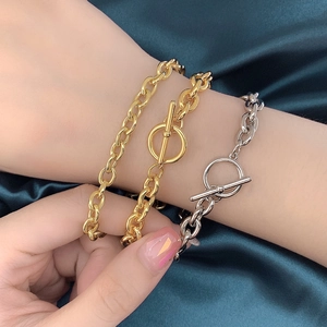 Elegant 18k gold and silver link bracelets with toggle clasp on silk background