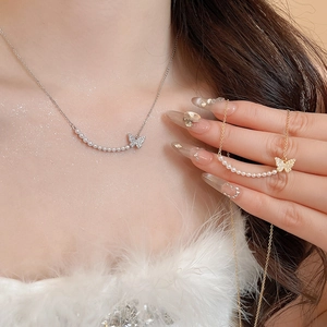 Detail of 18k gold butterfly necklace with pearls and sparkling crystals on model