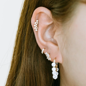 Macro shot of gold-plated S925 silver ear cuff and stud set with pavé diamonds