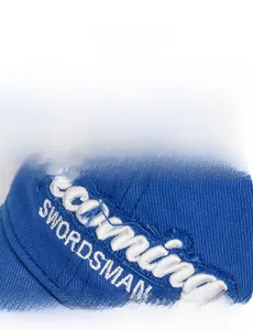 Detail of vintage navy blue golf cap with white frayed embroidery and distressed style