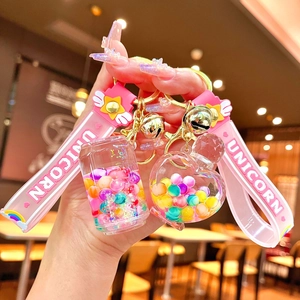 Pink unicorn keychain with liquid-filled bottle and heart charms on a gold clasp