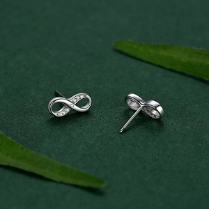 Elegant S925 silver infinity stud earrings with sparkling white zircons on dark green background