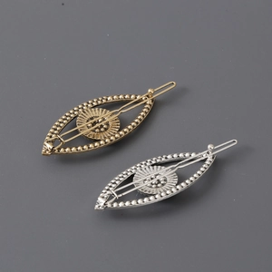 Exaggerated metal evil eye hair clips in vintage gold and silver with beaded texture