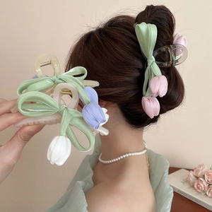 Detail of tulip hair claw clips with satin bows on a model and in hand close-up