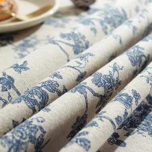 Close-up of blue floral print on linen tablecloth showing fabric texture and detail