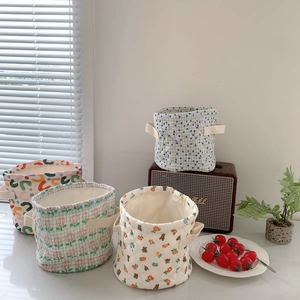 Detail of four quilted cotton storage baskets with diverse floral and geometric patterns
