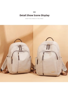 Detalle de la mochila de tela Oxford crema con asa de cuero marrón y logo dorado