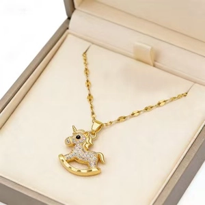 Detail of gold rocking horse pendant with white zircons on a fine cable chain