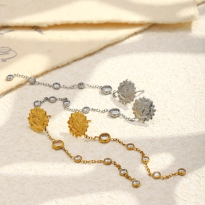 Vue détaillée des boucles d'oreilles soleil à pampilles en or 18K et argent avec zircons