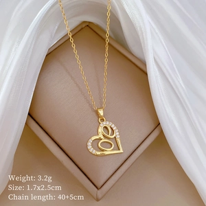 Close-up of golden hollow heart necklace with clear crystals in a jewelry box