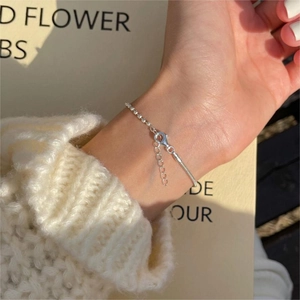 Close-up of S925 sterling silver chain bracelet with lobster clasp on knitted sweater