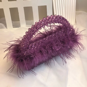 Detail of purple ostrich feather evening bag with elegant handcrafted beaded handle