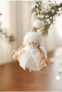 Close-up of white plush angel ornament with wooden skis on a Christmas tree