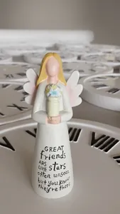 Detail of angel figurine with inspirational friendship quote on a long white resin dress