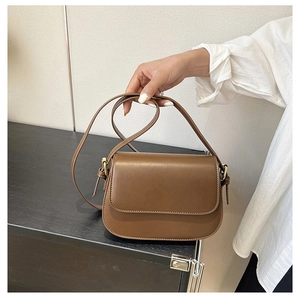 Detailed shot of a vintage brown leather crossbody bag with minimalist metal clasp