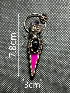 Macro shot of Triple Moon pendant with amethyst and onyx, size 7.8cm by 3.0cm