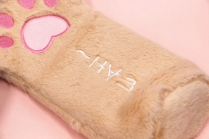 Close-up of soft khaki plush pencil case with embroidered pink cat paw design