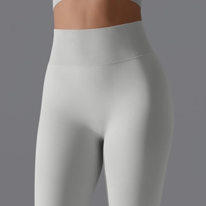 Detailed close-up of high-waist seamless compression waistband on light grey yoga leggings
