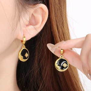 Celestial gold and black drop earrings with sun and moon motifs and crystal accents