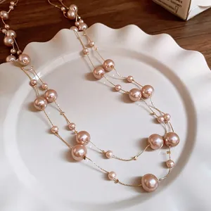 Elegant multi-layer champagne gold pearl necklace displayed on a white ceramic dish
