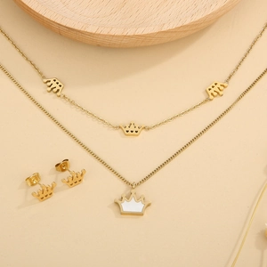 Golden double-layer crown necklace set with matching stud earrings on a wooden tray