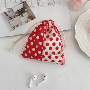 Polka dot drawstring cotton pouch for organizing small accessories on a desk setup