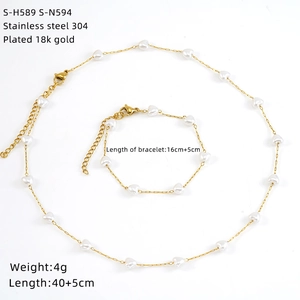 Detail view of 18K gold plated stainless steel jewelry set with white heart beads