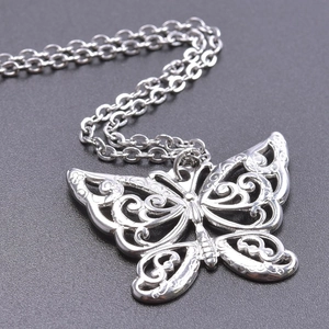 Detailed close-up of hollow butterfly pendant with vintage carved texture in silver finish
