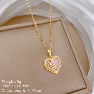 Detail of gold heart pendant with pink base, golden flower, and clear gemstone on O-chain