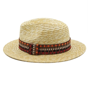 Detail of natural straw boater hat featuring a colorful ethnic style woven decorative band