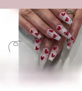 Detail of Valentine's press-on nails featuring red hearts and rhinestones, medium length