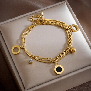 Detail of gold double-layered bracelet with Roman numeral ring and zircon pendant