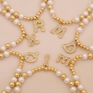 Elegant beaded bracelets with gold beads, pearls and sparkling rhinestone initial charms