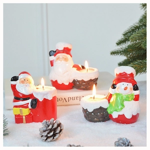 Close-up of Santa Claus and snowman candle holders with lit tea light candles