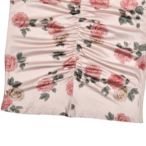 Detailed macro view of pink floral satin fabric with rose print and pleated design texture