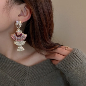 Nahaufnahme der Vintage Gold-Ohrringe mit bunten Strasssteinen und eleganten langen Fächern