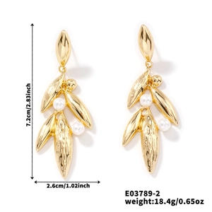 Detailed view of gold leaf drop earrings with white pearls and size dimensions in inches