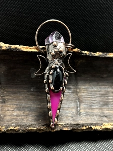 Macro detail of gothic bronze crescent moon pendant with amethyst and black agate stone