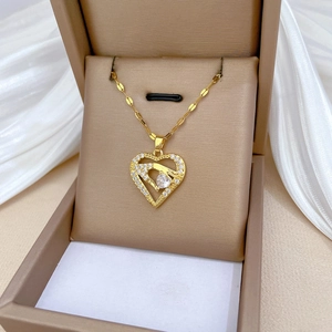 Elegant gold titanium necklace featuring a sparkling heart-shaped pendant with hands holding a gem