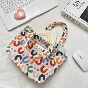 Vue détaillée du sac fourre-tout matelassé aux motifs colorés et accessoires de bureau