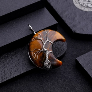 Macro detail of tiger eye crescent moon pendant with silver wire wrapped tree of life