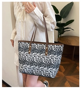 Détail du sac cabas léopard avec anses en cuir et finitions de rivets dorés chic