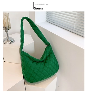 Dettaglio borsa hobo verde trapuntata con cuciture a rombi su supporto bianco
