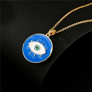 Collana dorata con ciondolo occhio del diavolo in smalto blu su fondo scuro