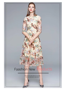 Close-up of elegant multicolor floral embroidery on ivory mesh fabric dress