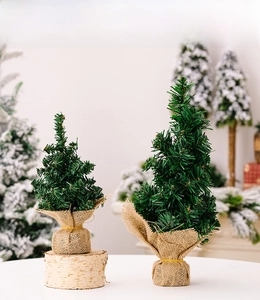 Detail of mini burlap-wrapped Christmas trees with natural birch wood bases for desk decor