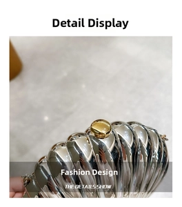 Close-up of a silver shell-textured acrylic handbag with a gold sphere metal clasp