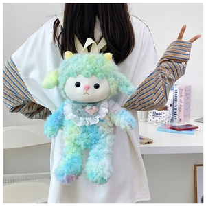 Detail view of rainbow plush lamb backpack with heart embroidery on model's back